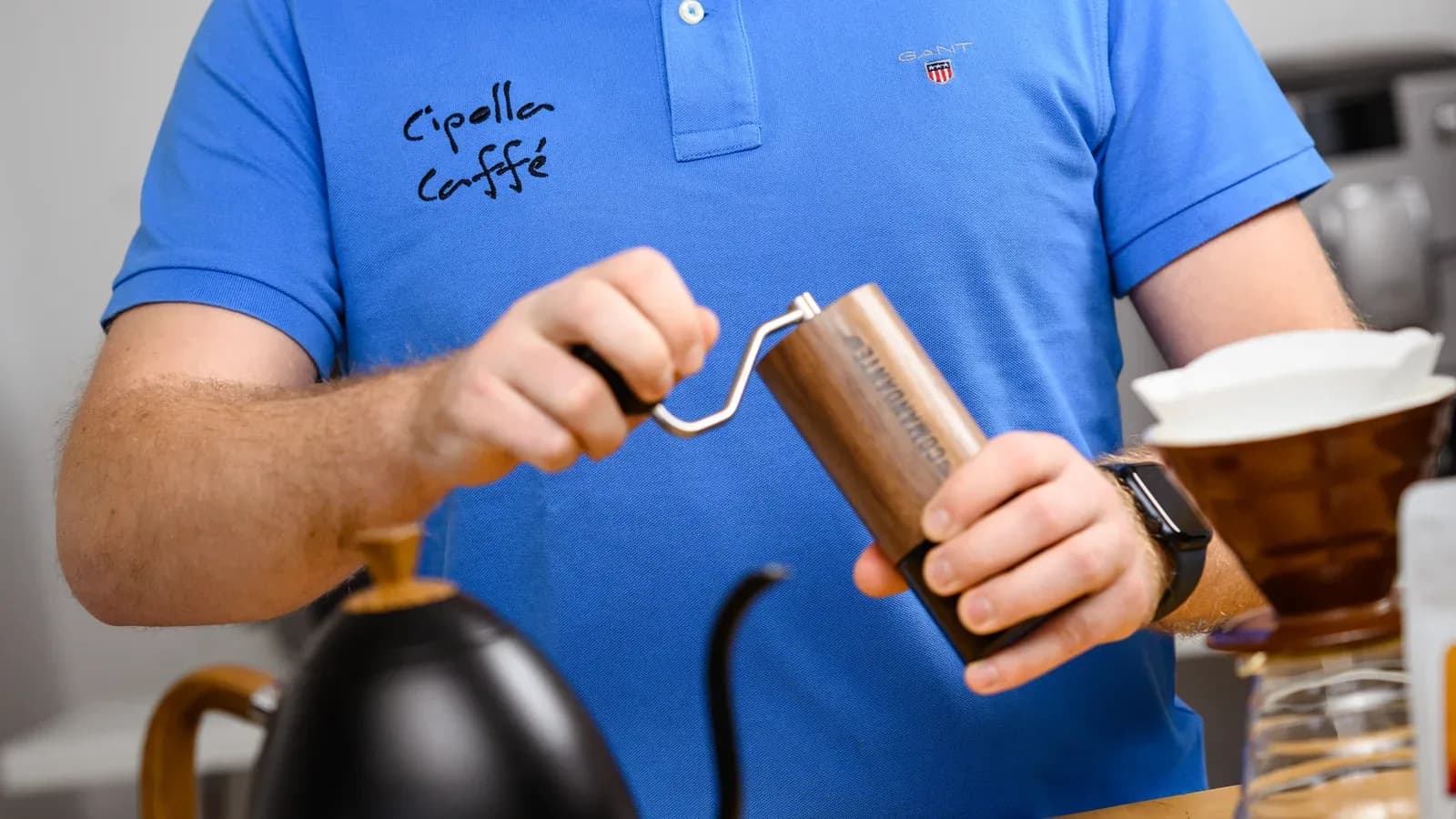 Domáca príprava filtrovanej kávy — ručný mlynček, kanvica s tenkým hrdlom a dripper V60